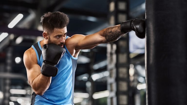 Young sportsman boxing workout at gym interior